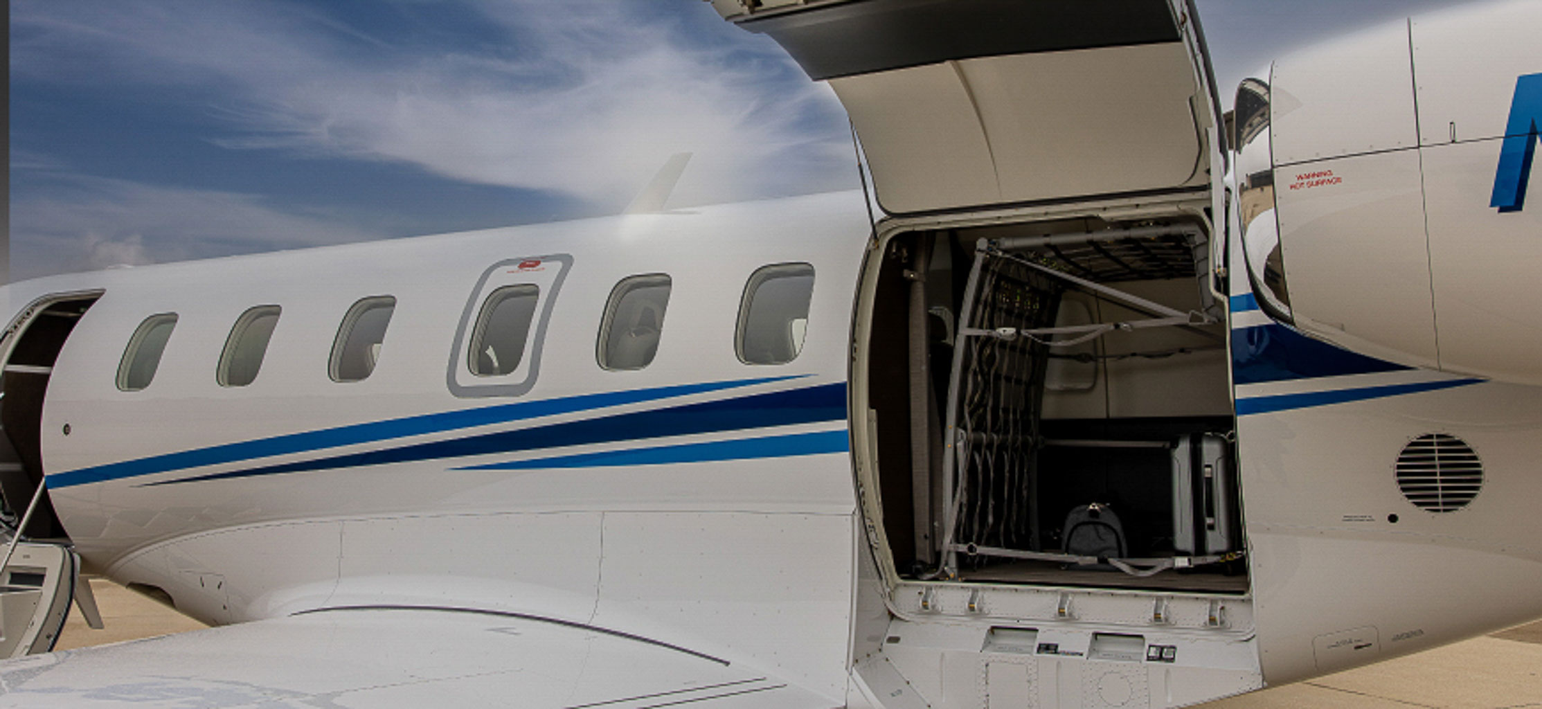 An outside view of a jet with a maintenance hatch open to reveal the inner workings